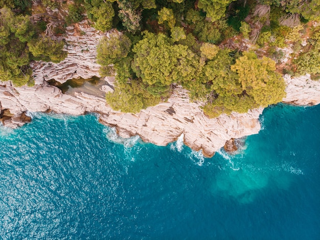 Vista superior de la orilla rocosa del mar Adriático cristalino, tiro de drone