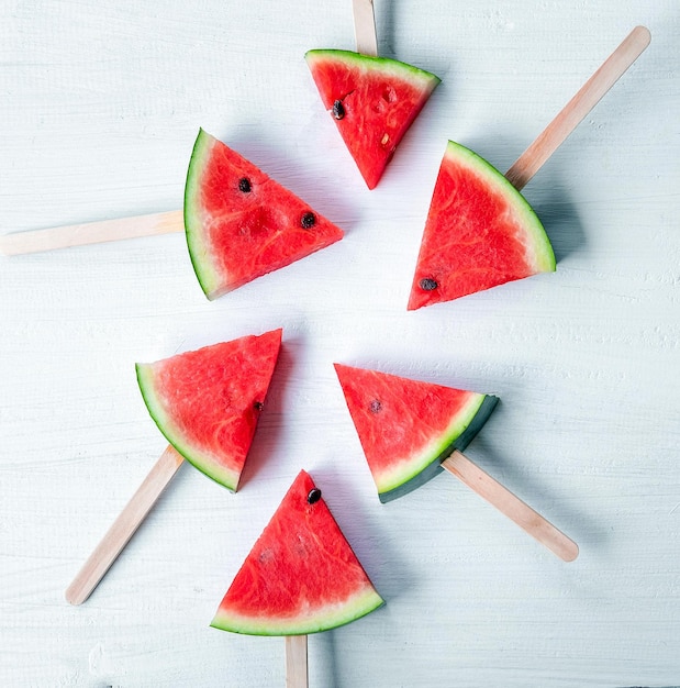 Vista superior de paletas de paletas de sandía sobre fondo blanco de madera