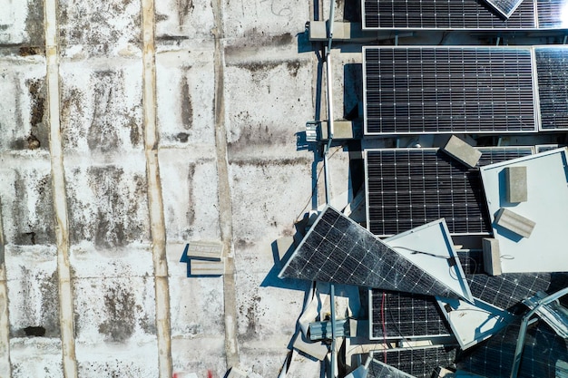 Vista superior de los paneles solares fotovoltaicos destruidos por el huracán Ian montados en el techo de un edificio industrial para producir electricidad ecológica verde Consecuencias del desastre natural en Florida