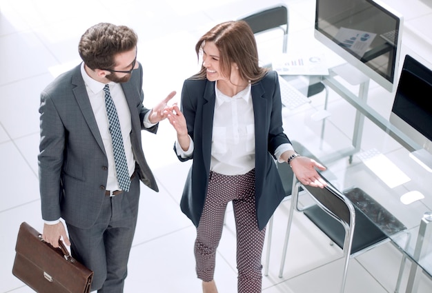 Vista superior pareja de negocios de pie cerca del escritorio