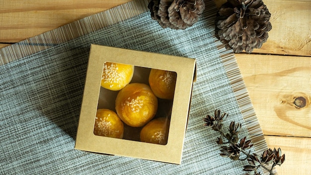 Vista superior de pastel de frijoles con yema de huevo salada en caja de papel