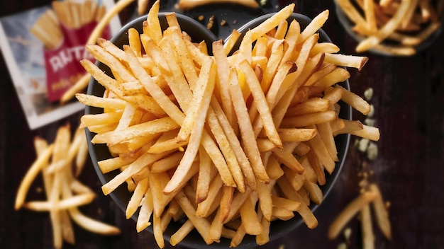 Vista superior patatas fritas deliciosas con condimentos en un plato de fondo oscuro comida de patata comida rápida bur