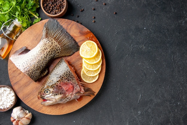 vista superior peixe fresco fatiado com rodelas de limão no fundo escuro refeição de frutos do mar oceano comida refeição salada peixes de água carne do mar