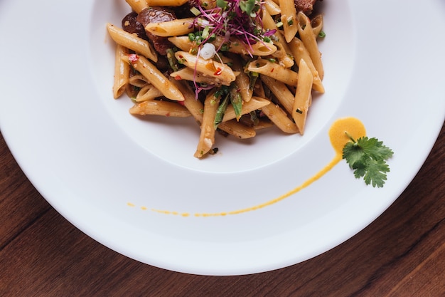 Vista superior de Penne con pescado crujiente y endulzar la carne de cerdo en salsa de chile picante tailandés.