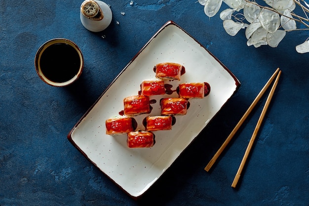 Vista superior de philadelphia rolls con caviar de salmón rojo y salsa unagi