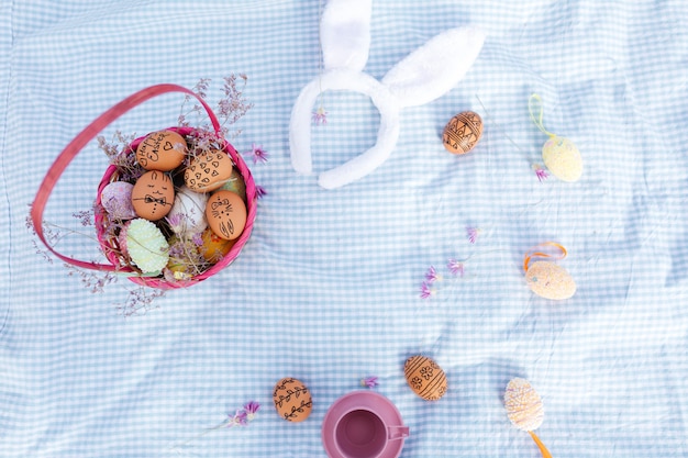 Vista superior de un picnic de vacaciones de pascua con huevos pintados