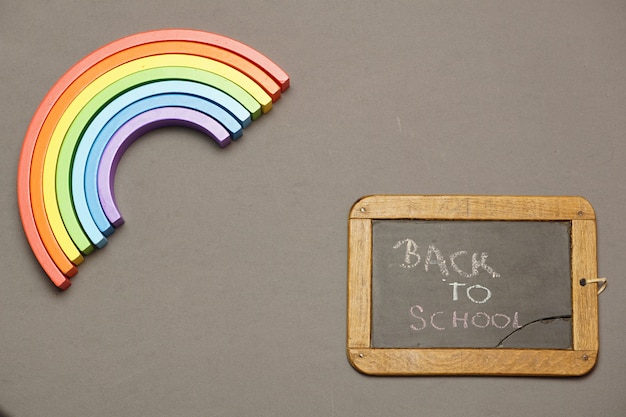 Foto vista superior de la pizarra con mensaje de regreso a la escuela y arco iris. covid 19. diseño plano laico plano