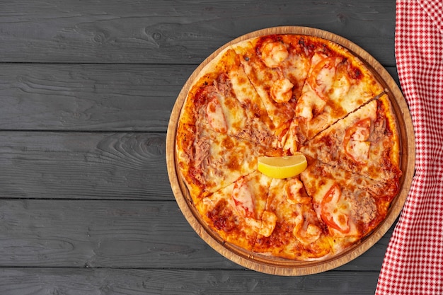 Vista superior de pizza caliente en mesa de madera negra