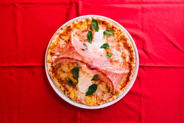 Vista superior de pizza napolitana hecha con tomates y queso mozzarella.