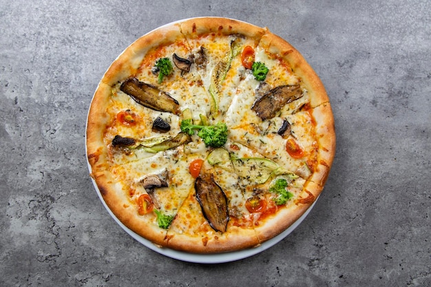 Vista superior de pizza vegana en un fondo gris