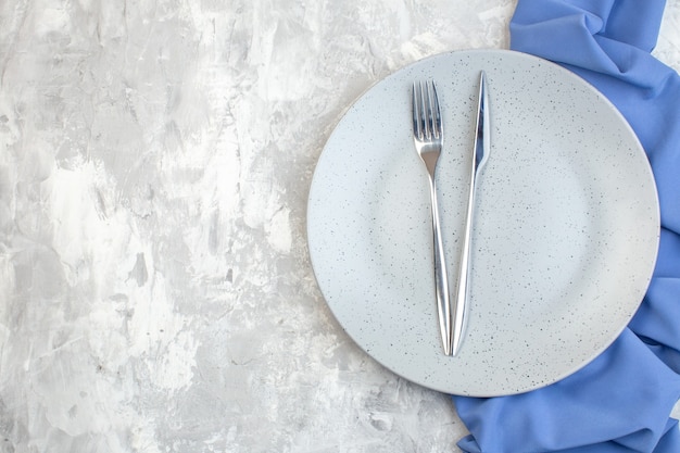 Vista superior de la placa blanca con tenedor y cuchillo en la superficie de la luz cocina señoras horizontal comida color comida vidrio familia feminidad