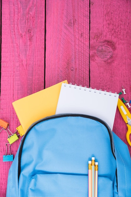 Vista superior plana de mochila escolar azul y herramientas de accesorios para la educación de los niños