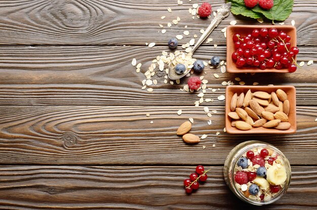 Vista superior plana en muesli de frutas en tarro de cristal en la mesa de madera de la cocina