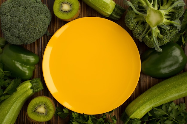 Vista superior del plato amarillo vacío, verduras y frutas