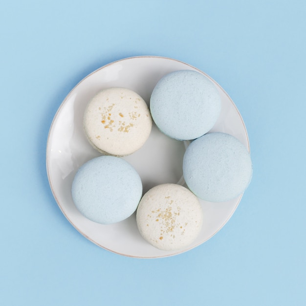 Foto vista superior en plato blanco con galletas de macarrón. dulce y sabroso postre galletas de almendras. composición de estilo minimalista.