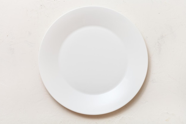 Vista superior del plato blanco sobre tablero de yeso blanco