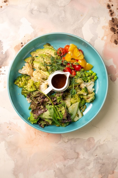 Vista superior de un plato de dieta equilibrada con verduras ensalada y aderezo ensalada cuenco