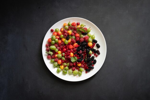 Vista superior de un plato con muchas bayas crudas frescas