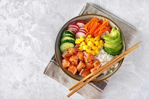 Vista superior del poke bowl con verduras, arroz y salmón.