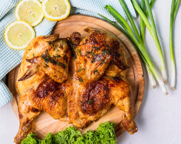 Vista superior de pollo entero al horno con rodajas de limón