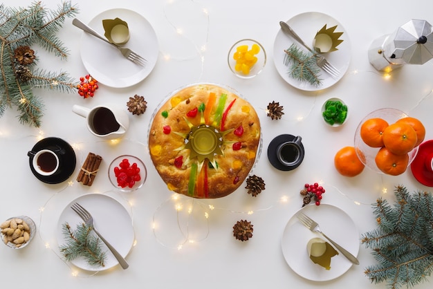 Vista superior del postre del día de la epifanía en la mesa con fruta y corona