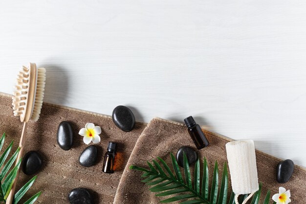 Vista superior de productos de spa orgánicos para masajes con aceite esencial y piedras zen negras