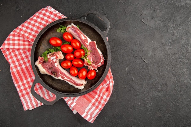 Vista superior rebanadas de carne cruda con tomates rojos dentro de la sartén sobre fondo gris carne pollo vaca cruda pimienta color foto animales