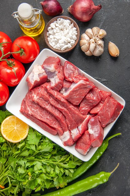 Vista superior rebanadas de carne fresca con verduras y condimentos