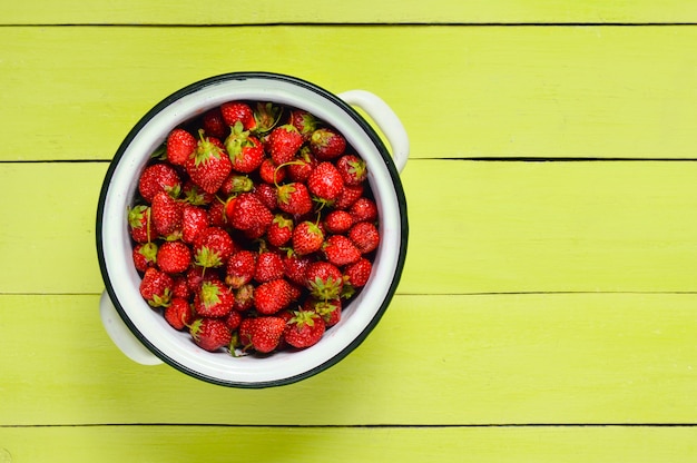 Vista superior del recipiente esmaltado con fresas maduras