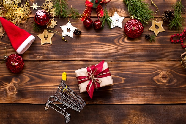 Vista superior del regalo con carrito de compras y adornos navideños