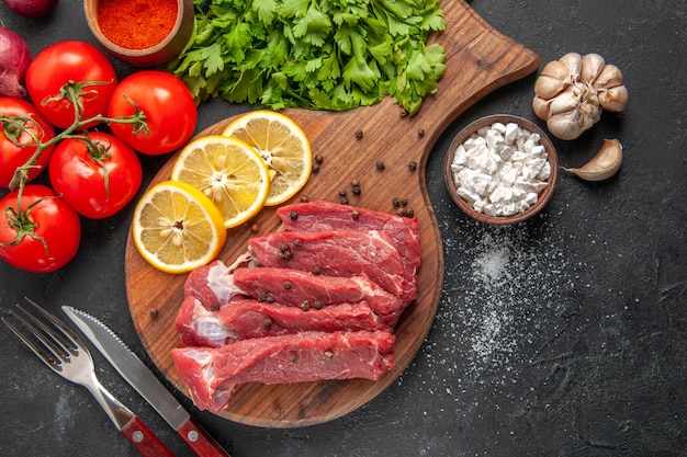 vista superior rodajas de carne cruda con rodajas de limón y tomates. comida cena carne comida