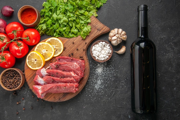 vista superior rodajas de carne cruda con rodajas de limón verdes y tomates. comida cena carne comida