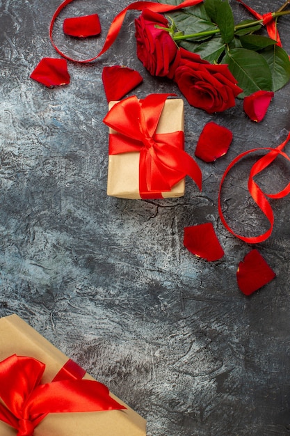 Vista superior de rosas rojas con regalos para el día de San Valentín sobre un fondo gris claro pareja matrimonio pasión corazón amor sentimiento festivo