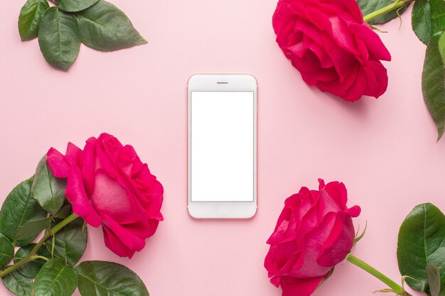 Vista superior de rosas rosadas con smartphone