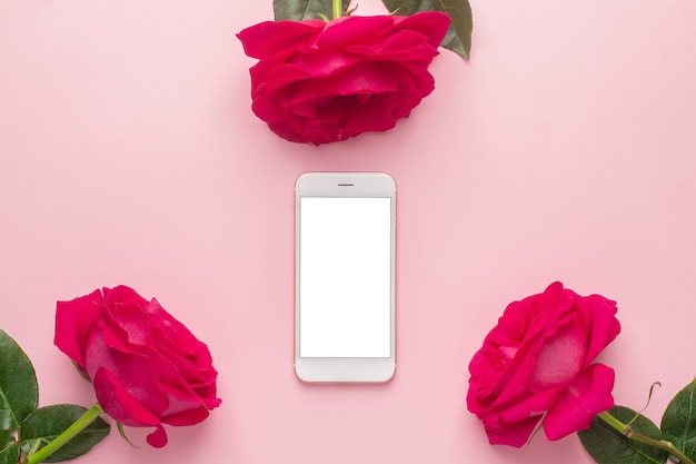 Vista superior de rosas rosadas con smartphone