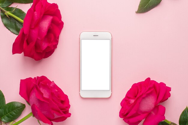 Vista superior de rosas rosadas con smartphone