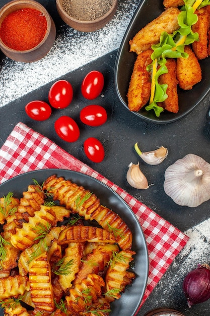 Vista superior saborosa batata frita com temperos e tomates vermelhos em fundo escuro foto de prato cozinhar fritar comida refeição carne frango