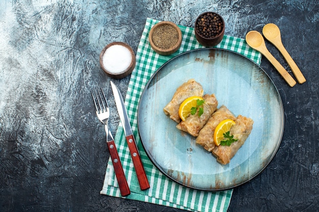 Vista superior saborosa dolma de repolho com rodelas de limão e temperos em fundo cinza cor de gelo prato calorias óleo jantar pão comida