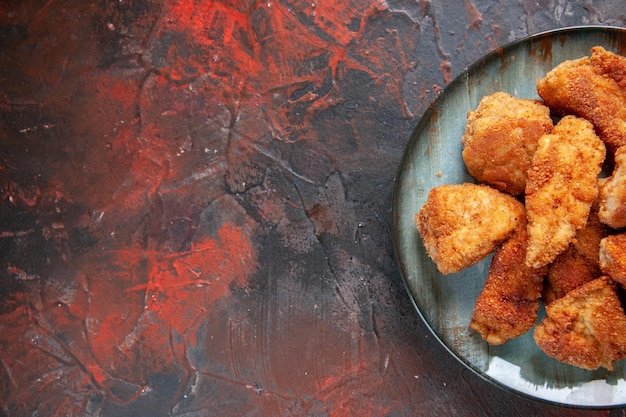 Foto vista superior saborosas asas de frango dentro do prato na superfície escura jantar comida batatas fritas carne almoço sanduíche refeição hambúrguer espaço livre