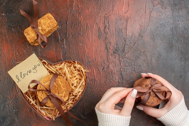 Vista superior saborosos biscoitos doces com anel em fundo escuro sentimento de casamento casal presente cor de feriado anel de biscoito amor