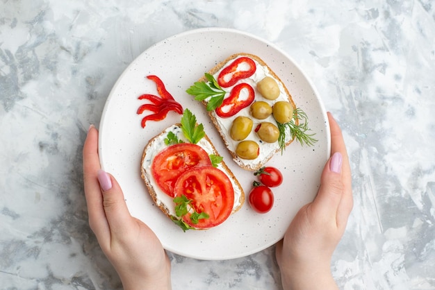 Vista superior saborosos sanduíches com tomates e azeitonas em fundo branco comida saúde refeição pão almoço torrada horizontal hambúrguer