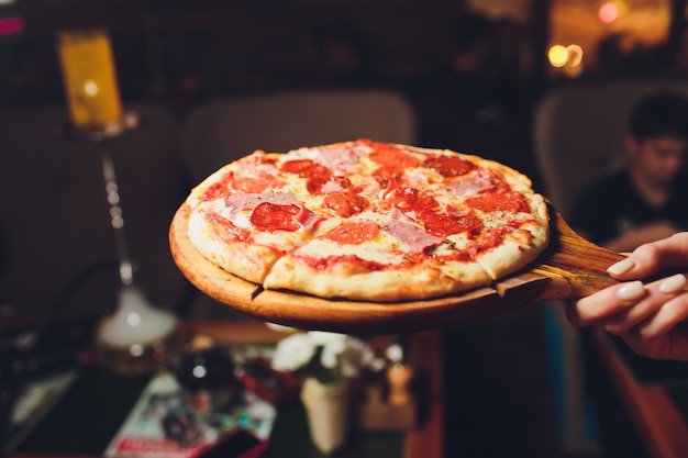 Vista superior sabrosa pizza italiana en la oscuridad