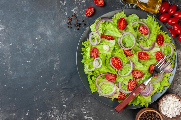 Vista superior salada de legumes fresca com salada verde cebolas e tomates em fundo cinza refeição salada comida foto colorida dieta madura