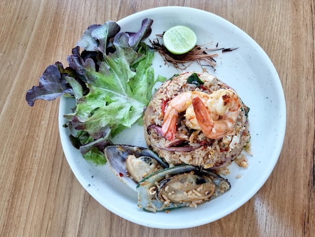 Vista superior Seafood Tom Yum Fried Rice em uma mesa de madeira, Camarão Calamari, Mexilhões