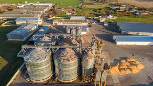 Vista superior de los silos de plata en la planta de fabricación agrícola para el procesamiento, secado, limpieza y almacenamiento de productos agrícolas, harina, cereales y granos Grandes barriles de hierro de grano Elevador de granero