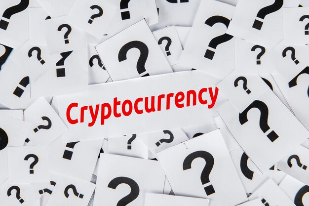 Vista superior del símbolo de las marcas de pregunta en los papeles con la palabra criptomoneda