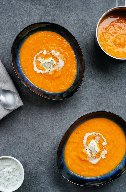 Vista superior de la sopa de calabaza en dos platos, plato y olla.