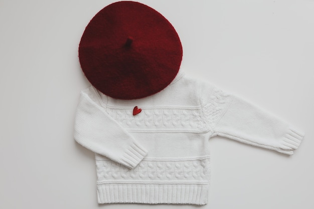 Vista superior suéter de lana blanca con corazón rojo