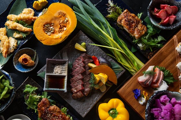 Vista superior sushi japonés kaiseki conjunto combinado de plato de comida fina en la tabla de madera con verduras dis