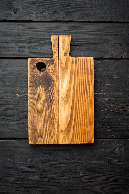 Vista superior de la tabla de cortar de madera vacía plana con espacio de copia para texto o comida en el fondo de la mesa de madera negra